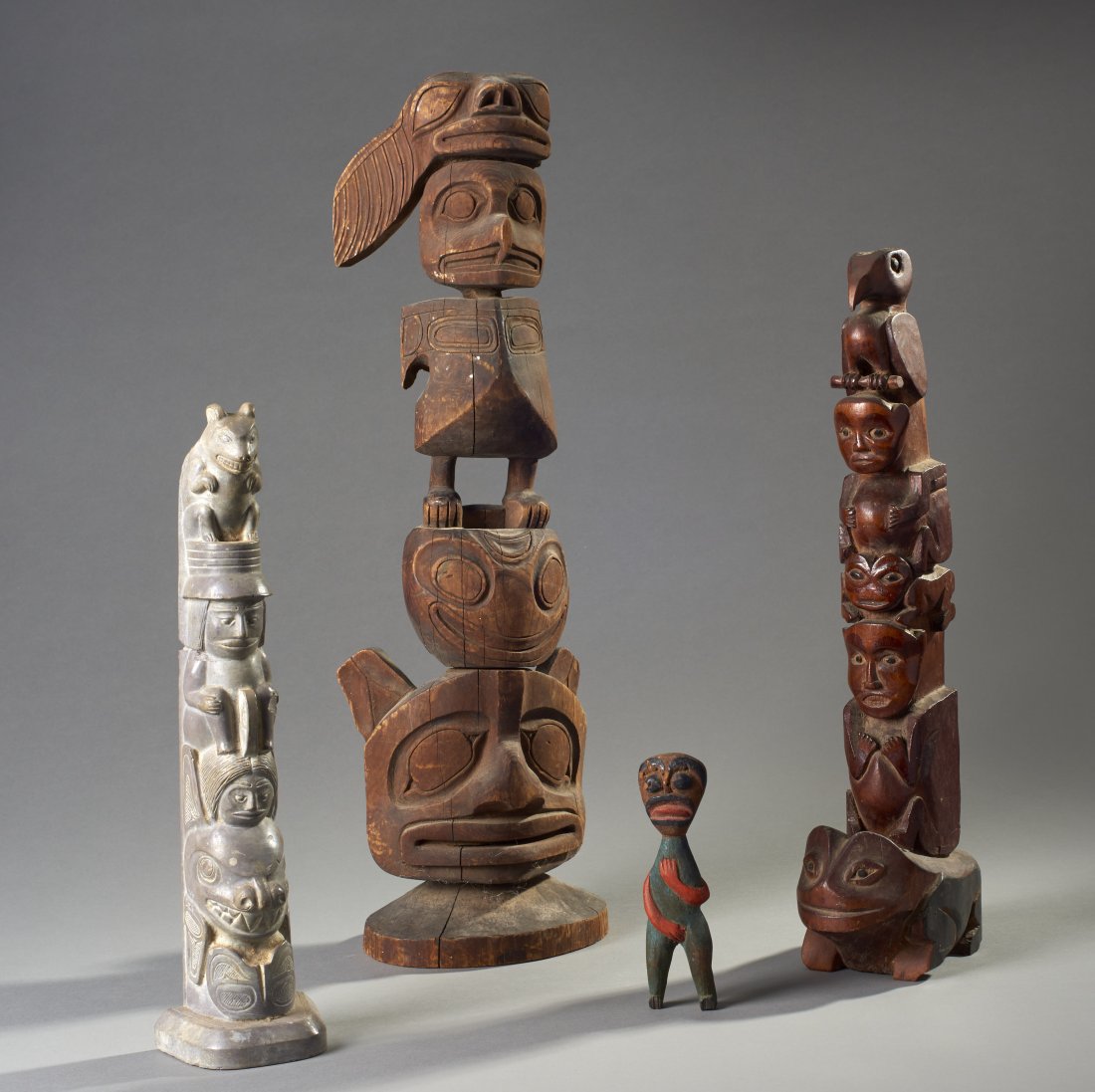 Four Northwest Coast Carvings: Northwest Coast North America, ca. 19th and 20th century. Four Native American carvings, consisting of a large totem of significant age, a smaller example probably first quarter 20th century, a stone 