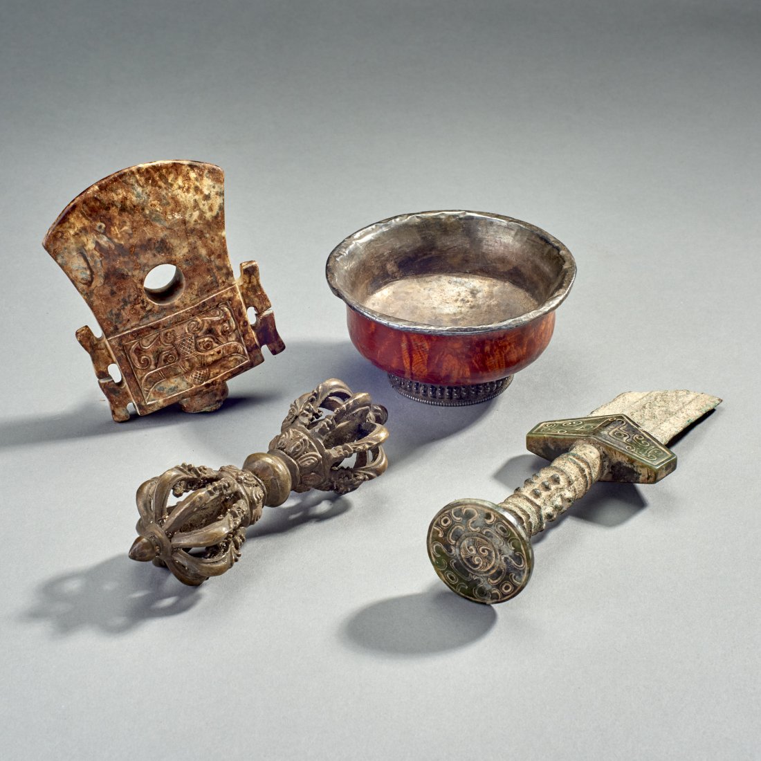 Four Tibeto-Chinese Objects: Four Tibeto-Chinese objects, 19th century and earlier. Comprising a bronze and hardstone sword fragment, possibly ancient, a Tibetan Vajra, a burl and silver cup, and archaistic hardstone axe head. Pr