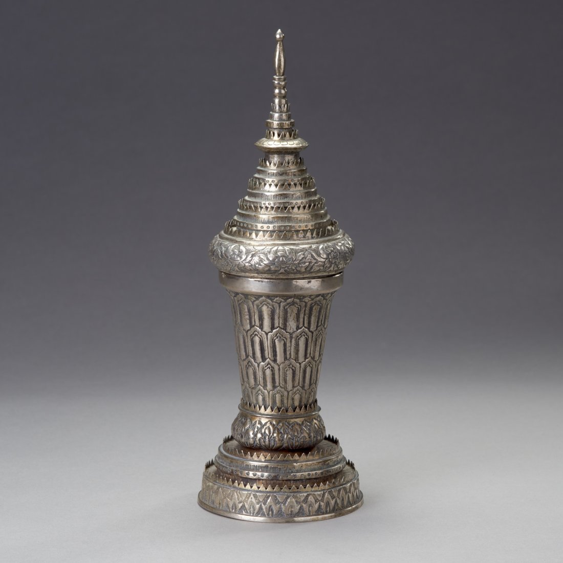 Thai Silver Stupa-Form Container: Thailand, ca. Late 19th-early 20th century. An unusual Silver stupa-form container or vessel constructed of numerous disk sections. Height: 10.3 inches / 26 cm