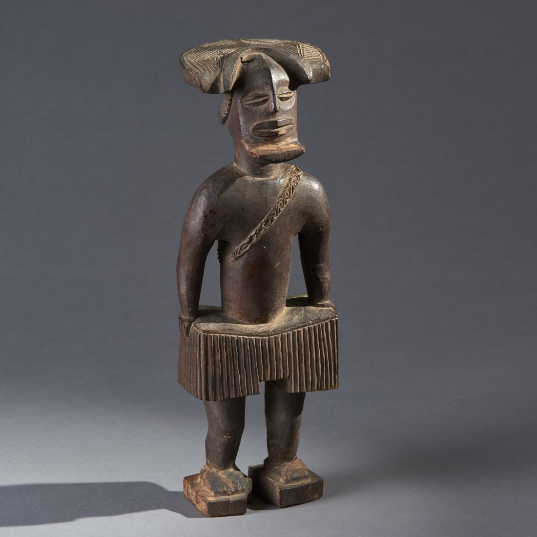 Fine African Wood Figure: Angola, Chockwe People, ca. 19th or early 20th century. Fine wooden male skirted figure with elaborate hair and projecting beard. Provenance: Old Connecticut estate. Height: 11 inches / 27.9 cm