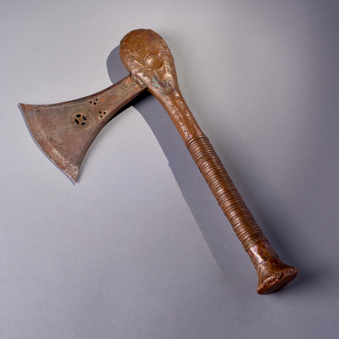 African Metal Axe: Africa, probably Songye, ca. 19th-early 20th century. A fine example with pierced and engraved blade, and the handle entirely sheathed in copper. Old Connecticut estate. Length: 14.3 inches / 36.2 cm