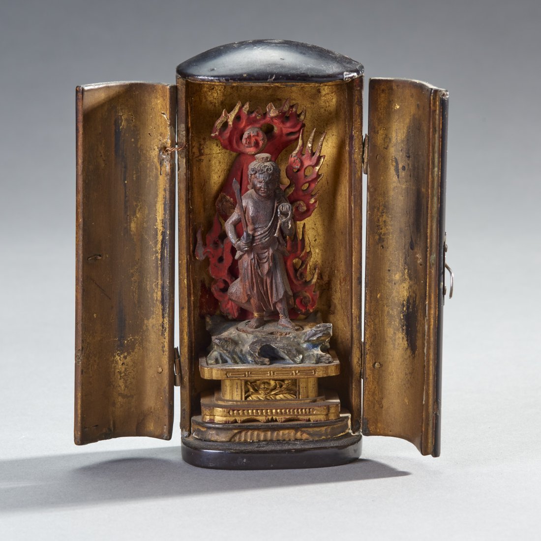 Small Japanese Portable Shrine (Zushi): Japan, Edo Period. Portable Zushi shrine, containing a small image of Fudu-myoo standing on rocky base with flame mandorla behind. Height: 5 inches / 12.7 cm
