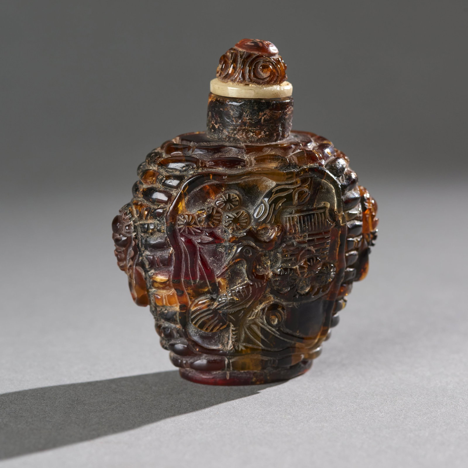 Chinese Carved Amber Snuff Bottle With Matching Stopper: Chinese carved amber snuff bottle with matching stopper. Measures: 2 1/2"