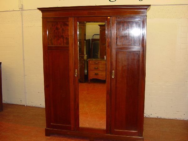 An Edwardian mahogany and inlaid large double wardr: An Edwardian mahogany and inlaid large double wardrobe having a centre mirror door with a full length door either side, 60 ins wide