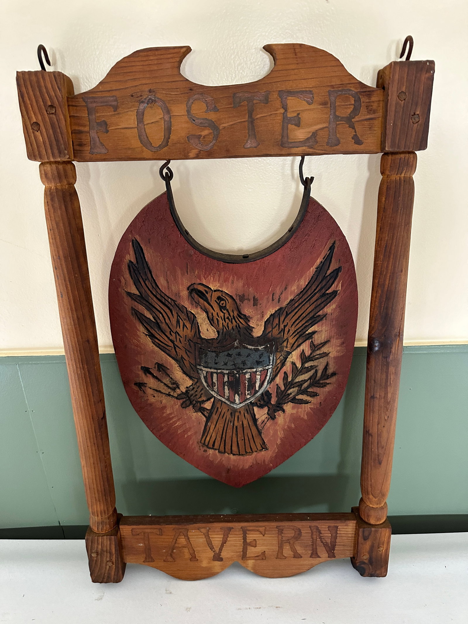Tavern Sign: wooden, hanging, Foster Tavern, pine, one sided, carved and painted with shield with eagle, not stamped but in the style of Armand LaMontagne