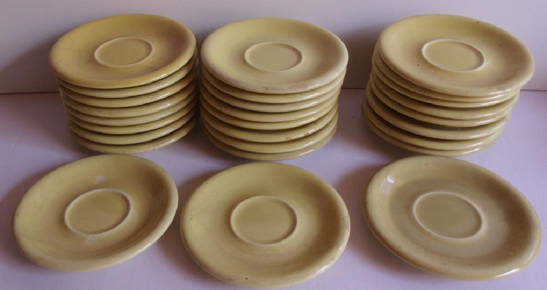 25 yellow Russel Wright plates: 25 yellow Russel Wright saucer plates. Chips; wear.