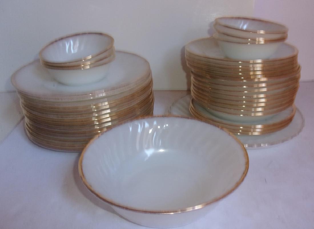 38 fire King plates and bowls: 38 fire King plates and bowls. Not a complete set. Wear to gilt. Largest plate measures 9 inches in diameter.