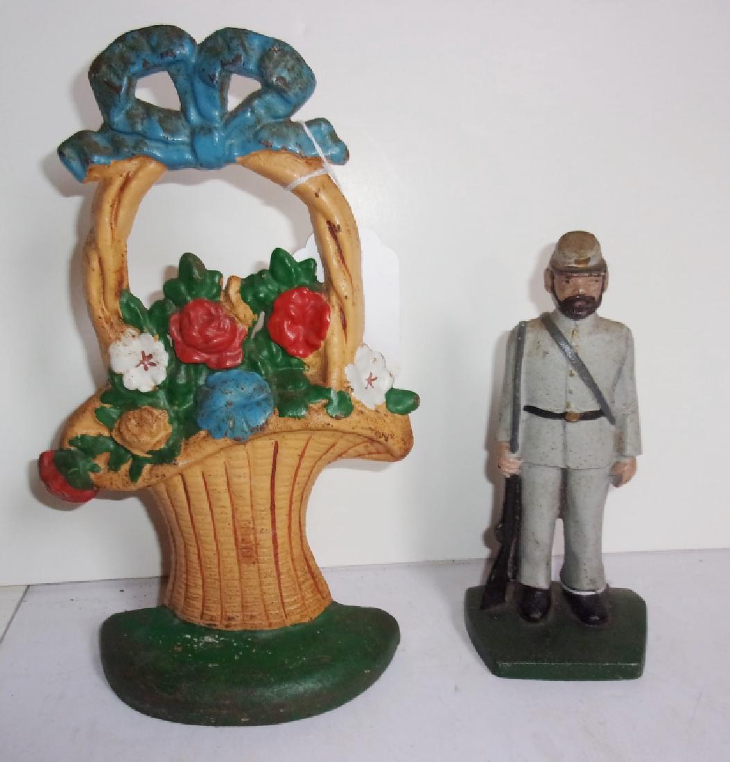 2 antique/vintage door stoppers: 2 door stoppers including vintage soldier; antique flower basket. Paint loss. Largest measures 10" x 5.5".