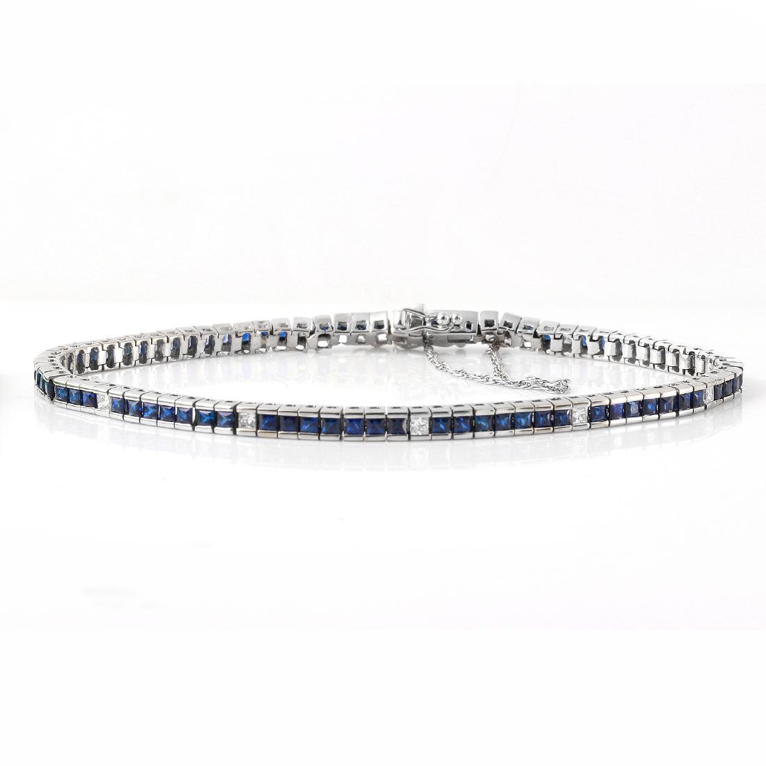 14KT White Gold Diamond Tennis Bracelet: This square link tennis bracelet features square cut blue sapphires, with intervals of princess cut diamonds, all in brightly polished 14KT white gold. A box clasp and safety chain secures the bracele