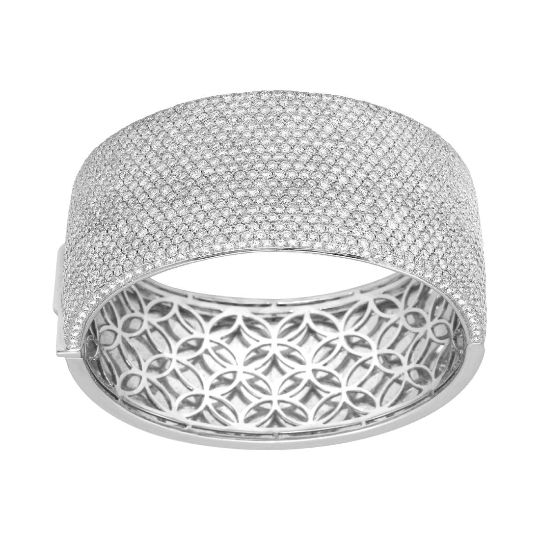 14KT White Gold Pave Diamond Bangle: Crafted in brightly polished 14KT white gold, this bangle bracelet is encrusted with round brilliant cut pave set diamonds, and closes with hidden clasp, snapping shut securely when placed on the wris