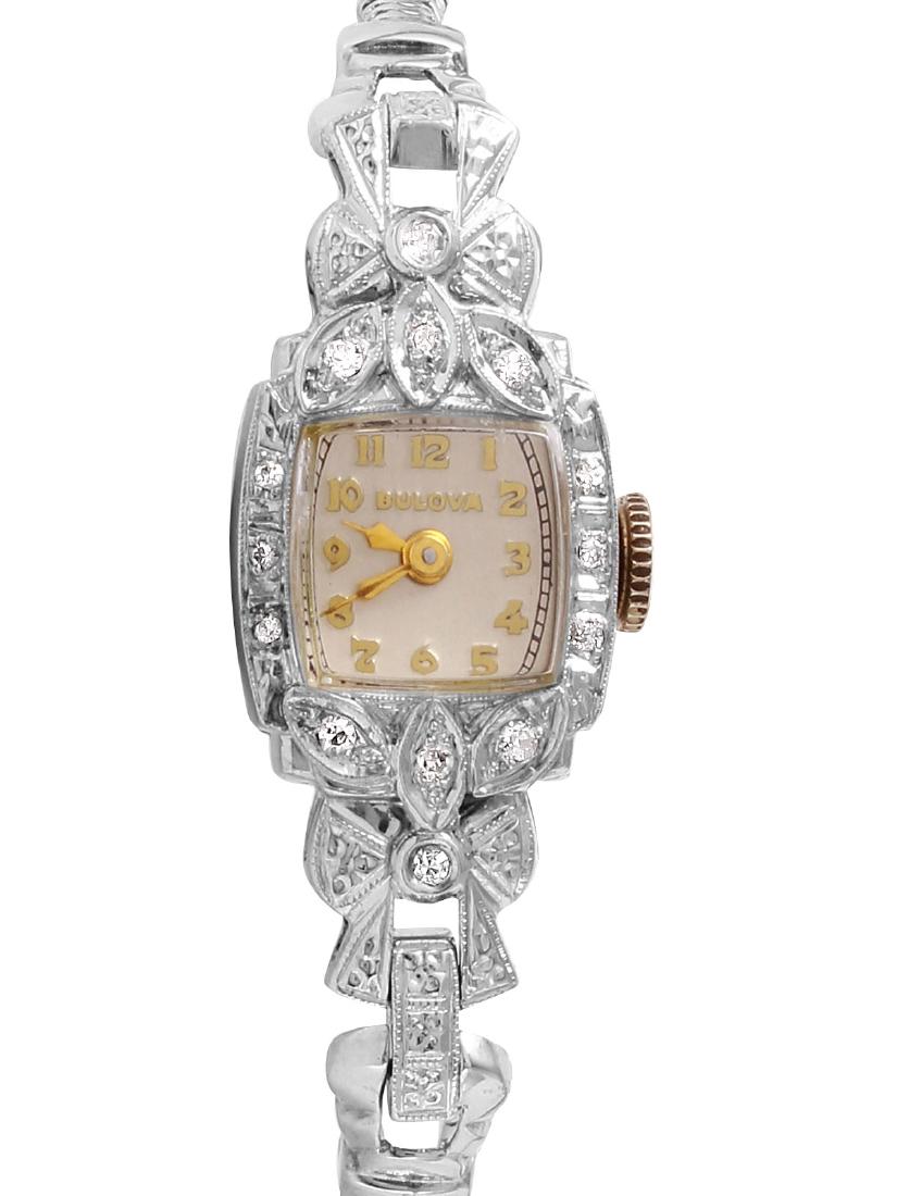 Bulova Diamond Bezel 14KT Gold Watch: Designer Bulova diamond 14KT white gold watch with manual wind. With diamonds that have been encrusted in the bezel and lugs, set in a beautiful Victorian style, finished with miligrain beaded detail.