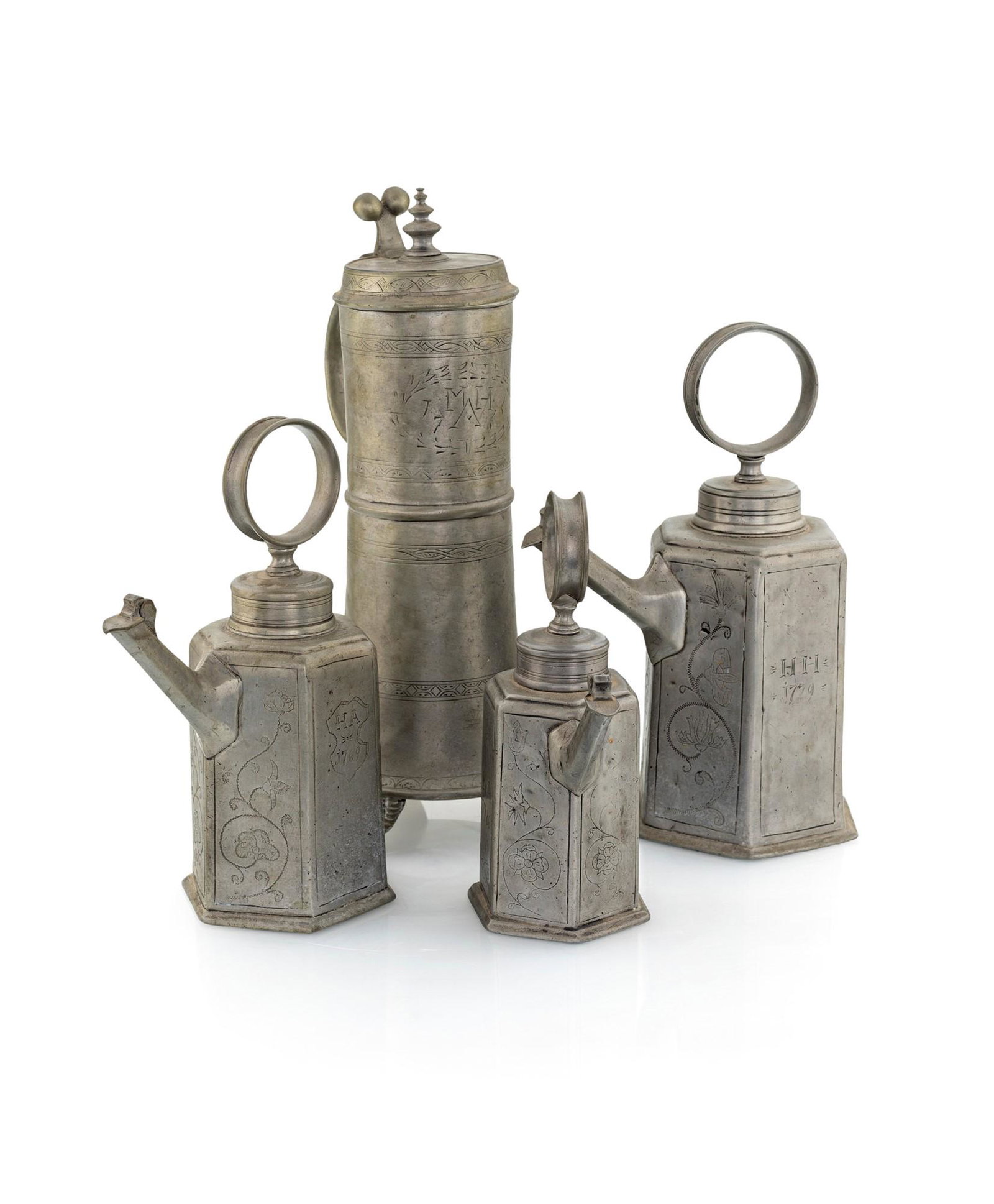 Lot of four pewter objects, late 18th century: a cylindrical mug and three polyhedral hexagonal coffee makers with shaped pouring spout with hinged cap and screw lid topped with ring socket.altezza cm 23, 26, 30 e 37