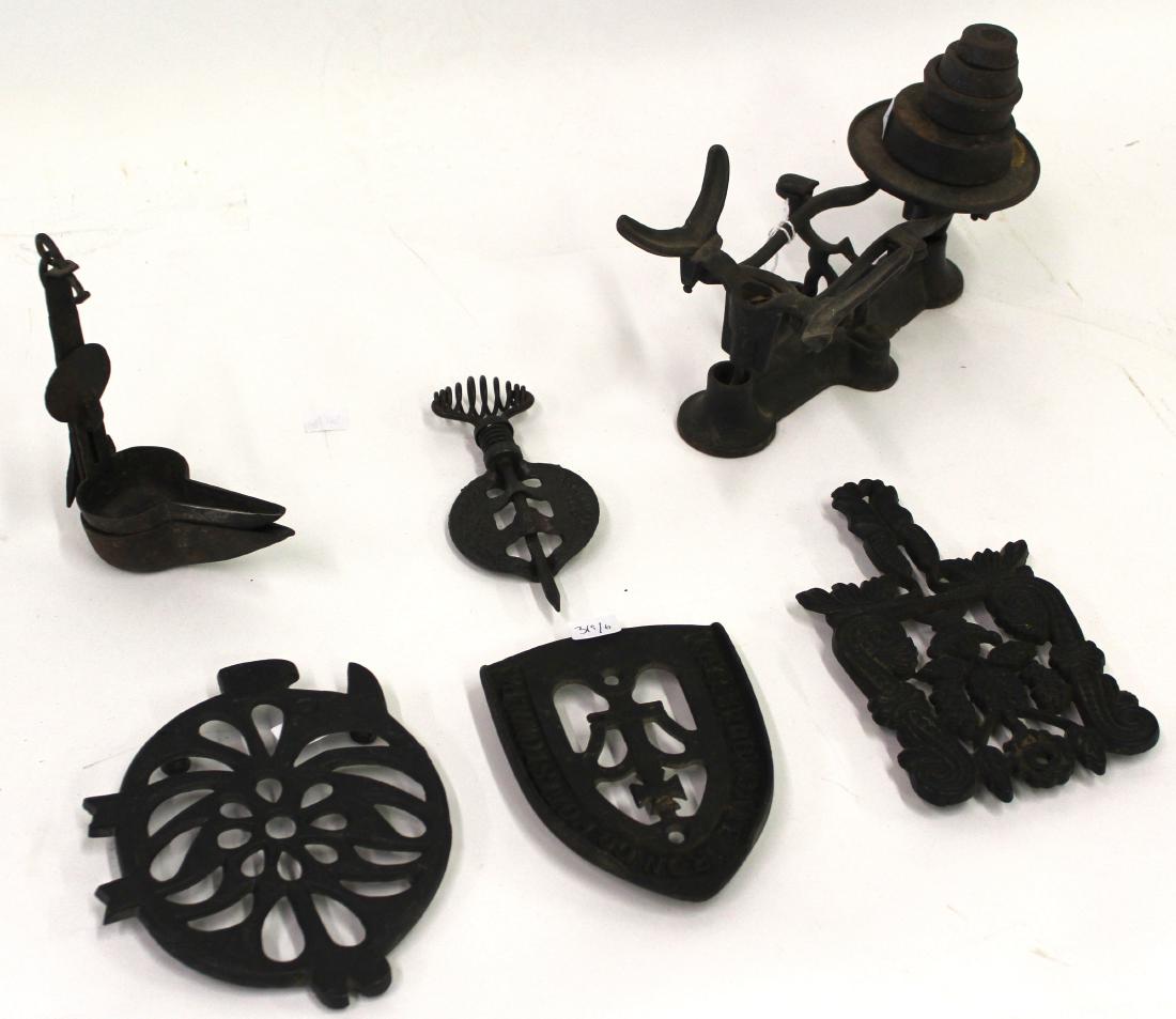 Collector' Lot of Cast Iron Antiques inc. Griswold: Cast iron trivets (3); Betty lamp; antique cast iron implement part, Griswold Erie Pa markings Included in the lot is a cast scale with four weights (no pans)Six items in the lot. Varying sizes.