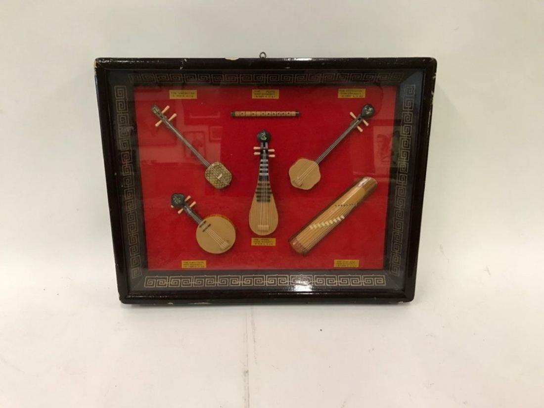 Chinese Miniature Instruments . Various Dynasties: Hand made examples of Chinese instruments representing various Dynasties. In a lacquered Chinoiserie frame. Examples of Yueh-Chin; Ming; Tang , Swei Dynasties and others. Instruments each have identif