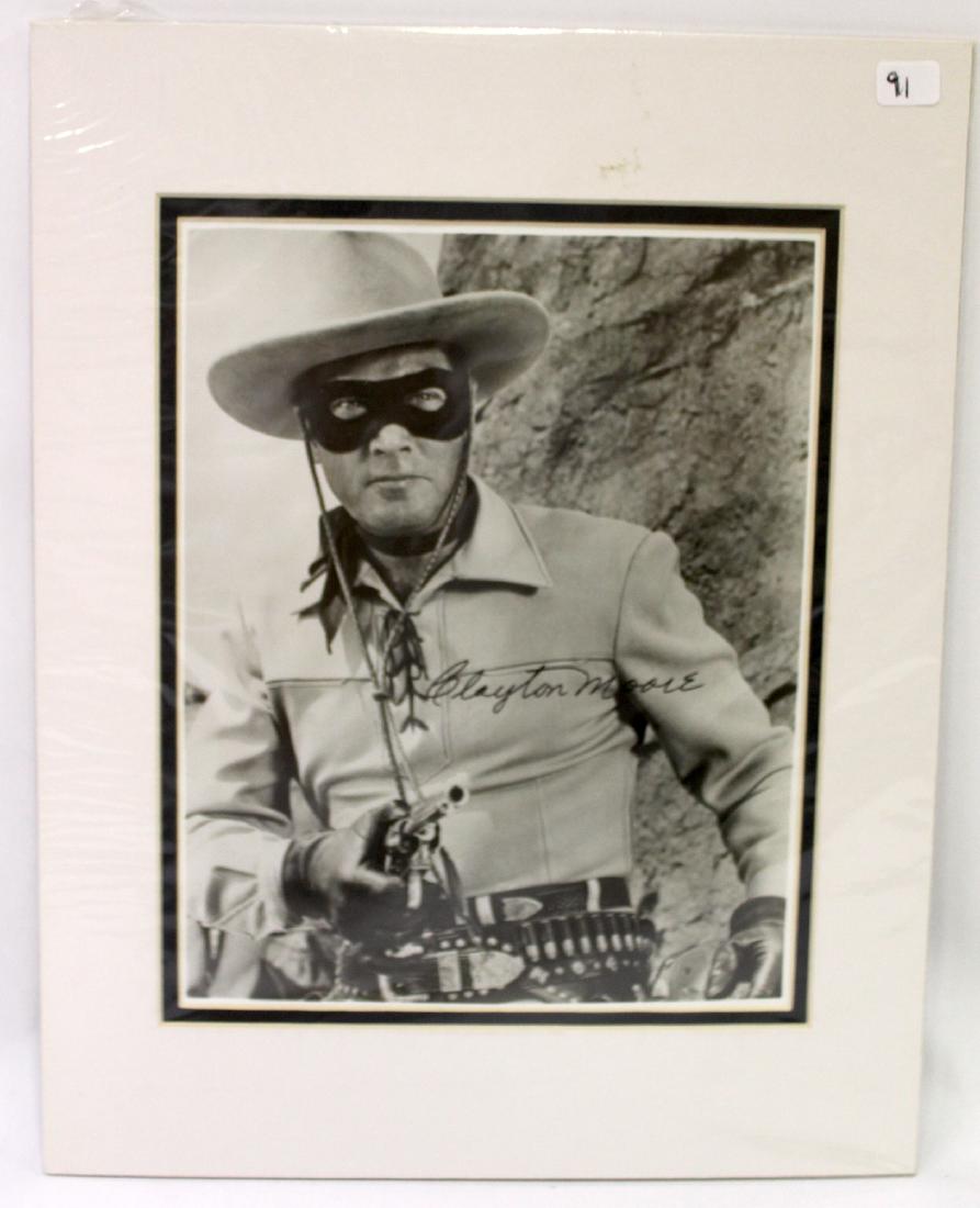 Clayton Moore Sgd. Photo: Matted Photo of Clayton Moore in Cowboy Attire pointing a Revolver at the camera. Signed Clayton Moore. Overall Size 14"H X 11"W