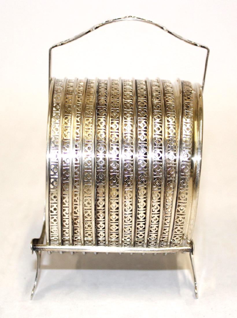 Sterling Rimmed Coasters in Sterling Holder: Eleven glass coasters with sterling silver rims in a sterling silver holder.. 3"W 5"H.