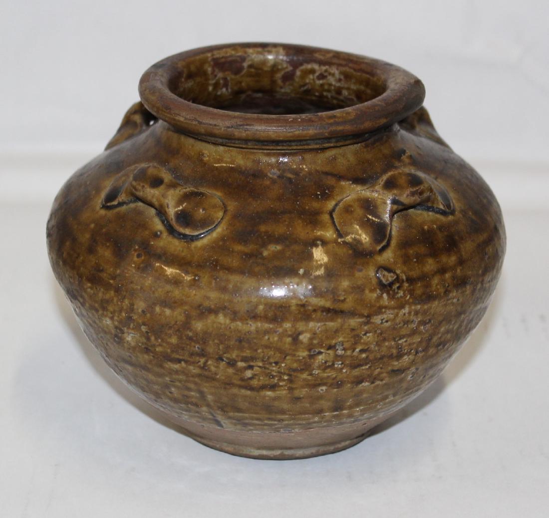 Six Dynasties (220-589) Pot of Yue Ware: In this case, a small compressed version with four lug handles or tie downs, produced shortly after the Han Dynasty, likely from the kilns at Zhejiang Province and dating from the late 3rd. to 4th cen