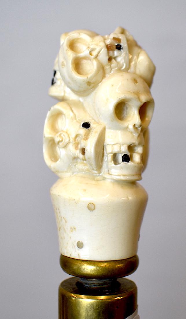 Walking Stick. Figural Handle Skeleton Skulls.: Ebonized shaft with brass ferrule and collar. Carved bone multiple skeleton heads form the handle of this cane.