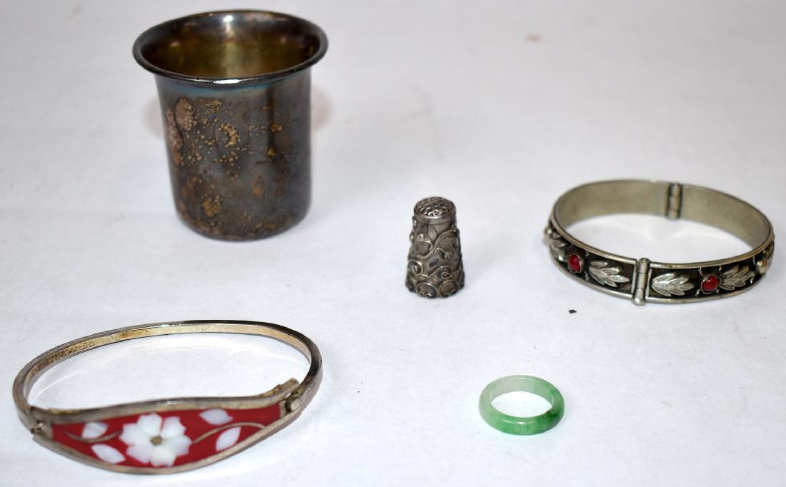 Collectors Lot. Sterling, Jade and Silverplate: Collectors lot to include a French sterling shot cup with hallmarks; a highly repoussed sterling thimble; a jade ring; a silverplated bracelet and an enameled bracelet. Five items in the lot. Varying 