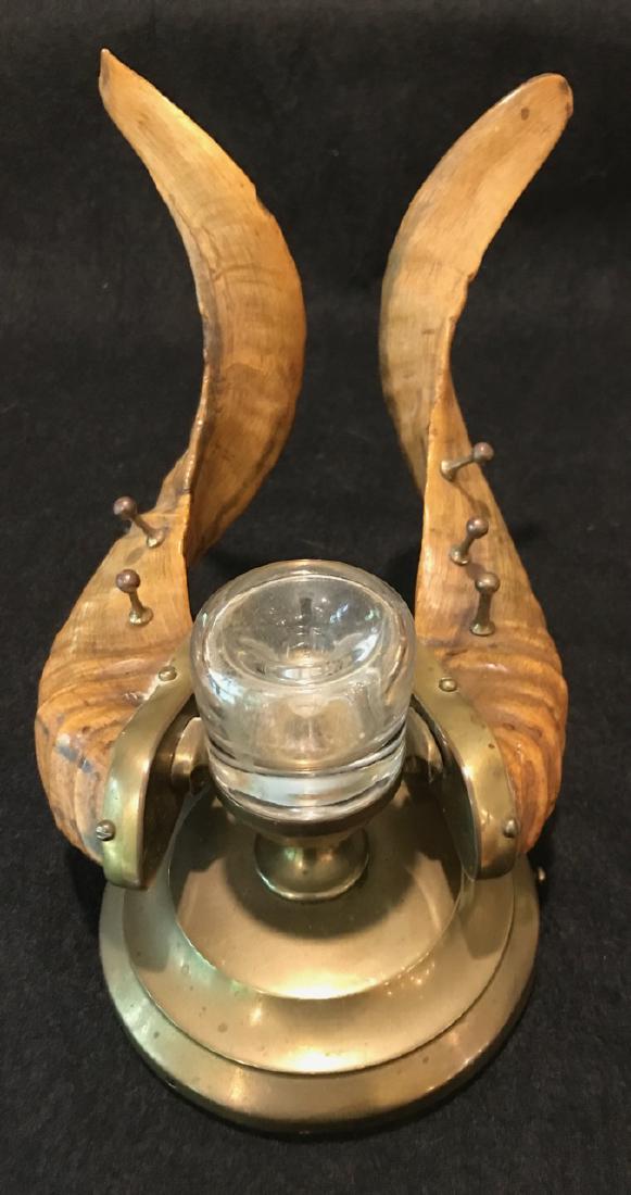 Ram's Horn Pen Holder and Inkwell: Brass stand holds glass inkwell flanked by two ram's horns with brass studs for holding up to three pens. One stud is missing as shown in photos. Minor horn chips at the tips of the horns. 6-3/4" H x 