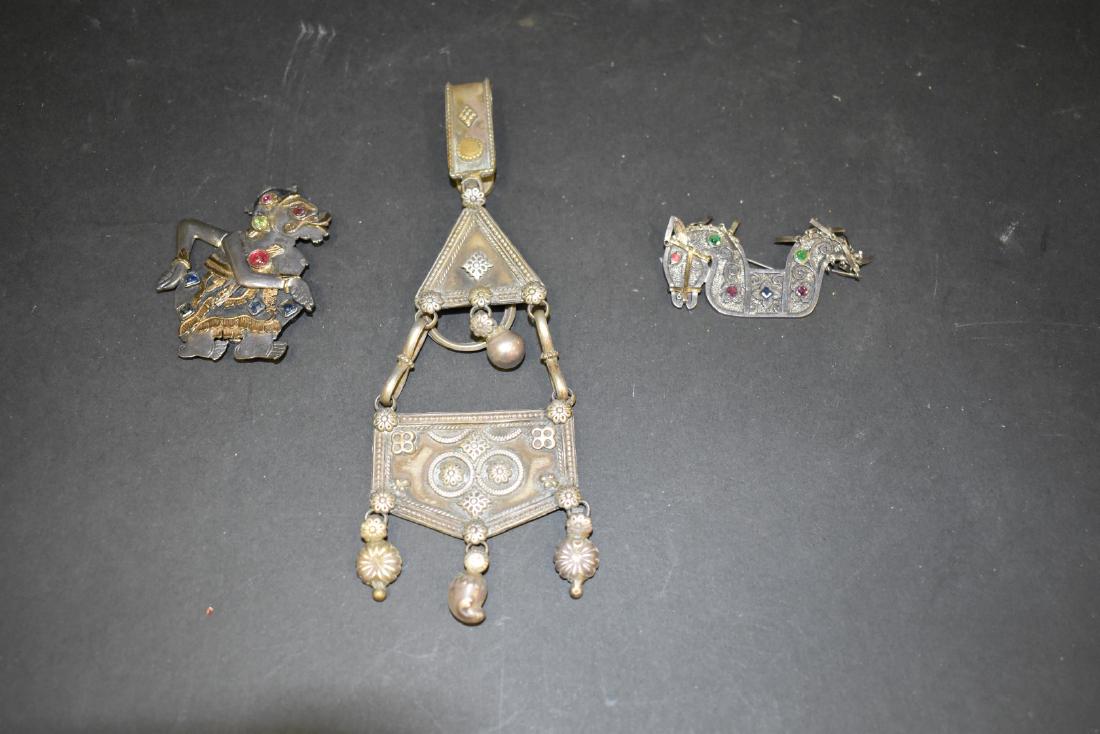 Three(3) Miscellaneous Indonesian Items: Including: a silvered belt adournment(6in.H.); two(2) silvered brooches with gold embellishments and hardstone decoration; 2in. - 2.25in.H.