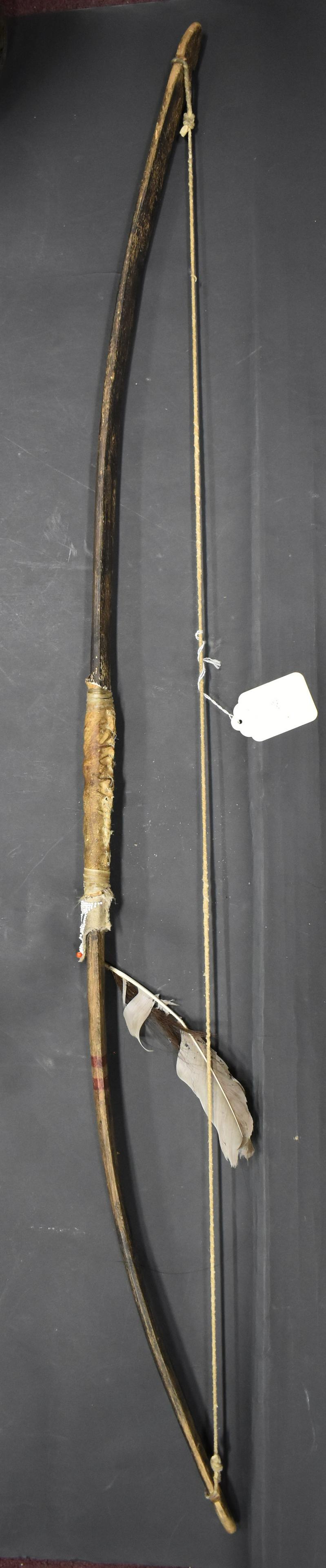 Native American Indian Bow with Bead Trim: All original . Rawhide wrappings. Feather attachment. Beadwork 51"L