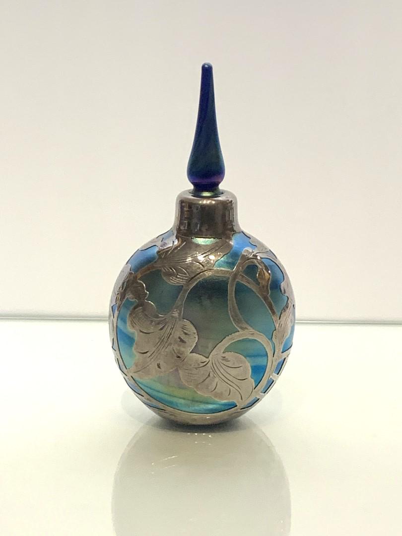 French Art Nouveau Silver Overlay Glass Perfume: Blue iridescent art glass perfume with stopper. Silver overlay leaf design. Marked France and silver stamped .999; 6.5in.H. x 3.25in.W.