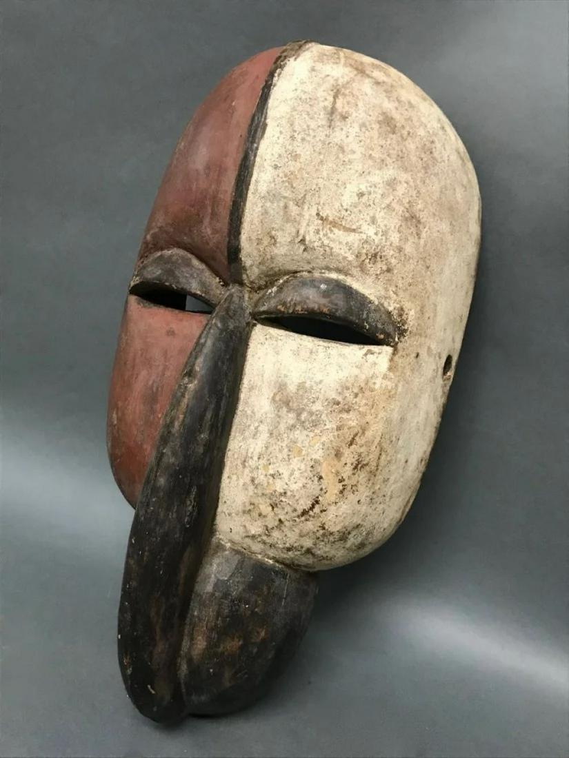 Old West African Tribal Mask, Gabon: The face partially imbued with natural black, white lime and a red earth bole coating, it shows wear from use. Vuvi peoples, Gabon, 15.5 inches high x 5 inches wide. .****This, an item from a local el