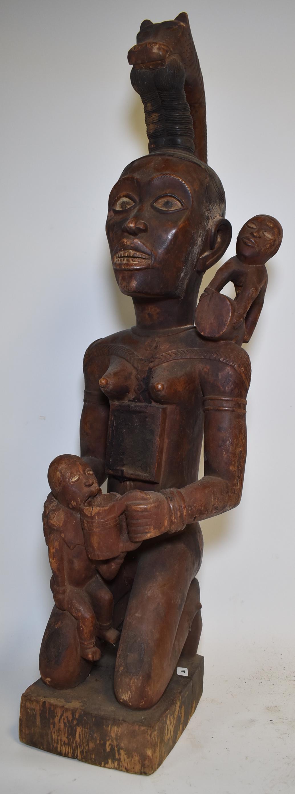Very Fine Congolese Royal Figure: Yombe related. Mirrored chest female. Royal serpent crown with mica eyes. Maternal. She feeds her young. Strong age. Reddish cam embued surface. 32"H.