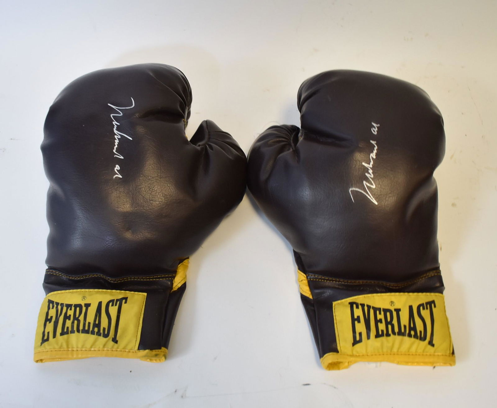 Pair of Muhammad Ali Autographed Boxing Gloves: Pair of autographed boxing gloves. Brown Everlast. Silver felt tip marker signatures; 11in.`
