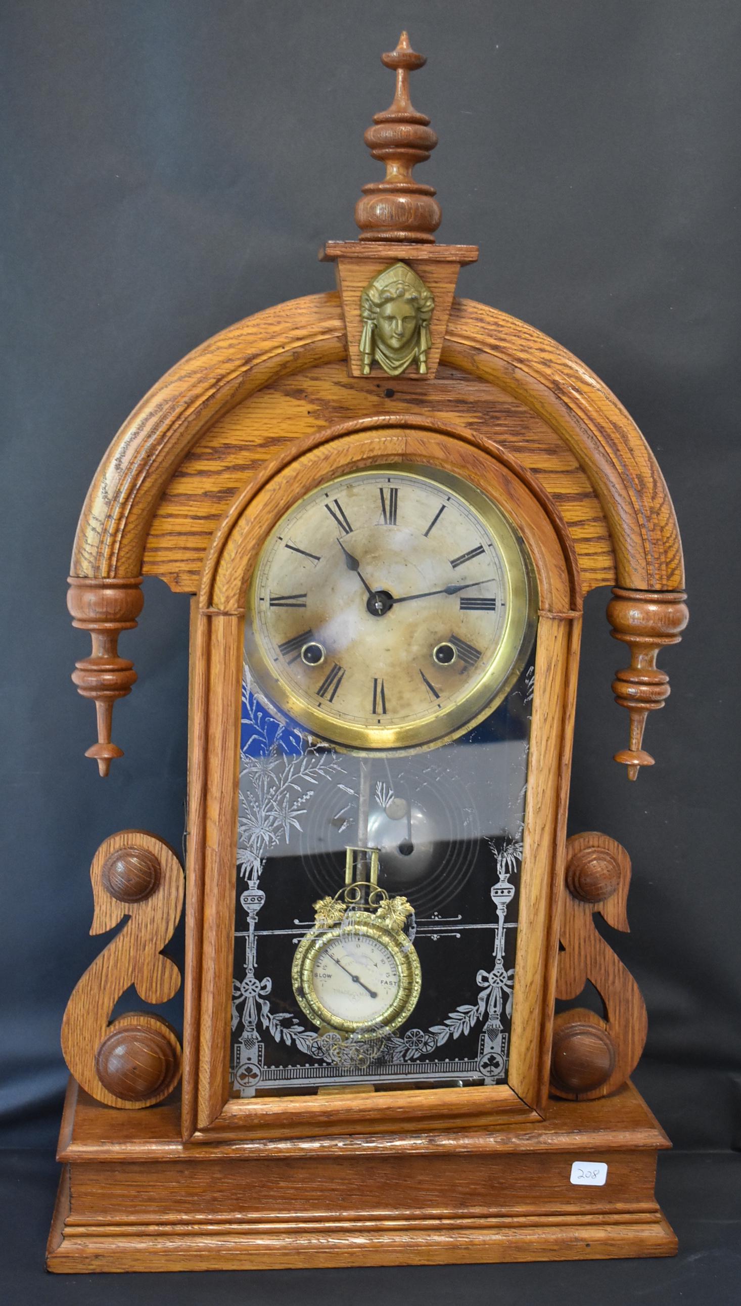 Ansonia Gingerbread Victorian Clock: Ornate brass surmount Stenciled glass door (worn) Time and Strike Oak 25"H. 13"W