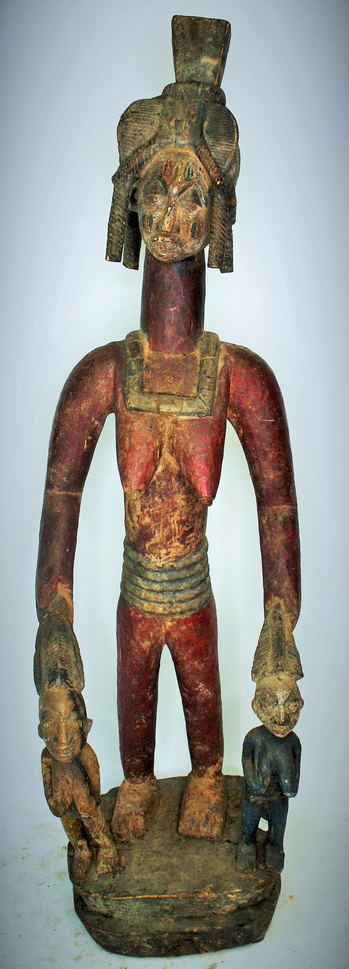 Rare Lg. Antique Yoruba Queen Mother Figure: Rare Lg. Antique Yoruba Queen Mother Figure. She holds a pr. of female daughters. Central Nigeria. Royal head dress and neck emblem. Extensive scarification on reverse. About Mid 19th C. 43"H