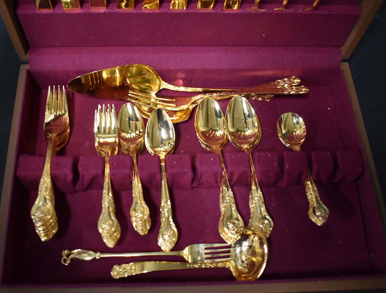 Gilded Flatware Set (59): 8 steak knives, 3 butter knives, 8 forks, 8 Dessert forks, 16 desser spoons, 8 spoons, 3 soup spoons, 5 serving utensils.