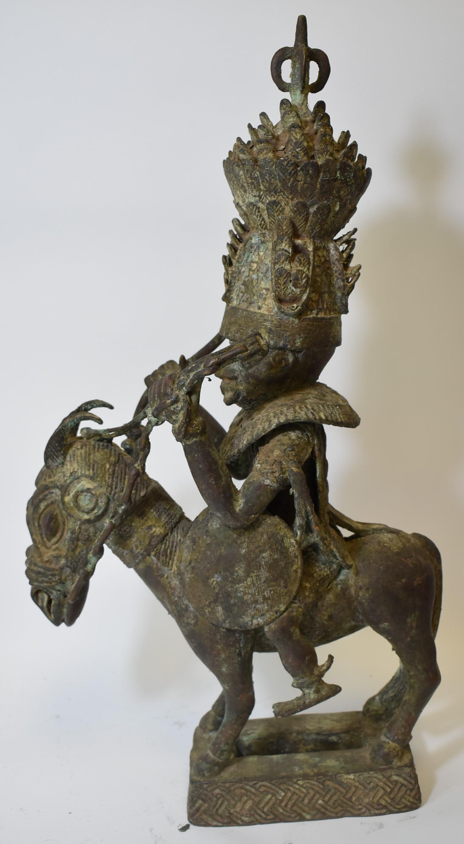 Fine . Benin Bronze. Guardian of Oba: possibly earlier. Guardian warrior of the Oba's King . Royal Crown, weapon etc. On stead. In regalia of Royal support, a privileged guardian of the king, the Oba. This high quality bronze is likely a 