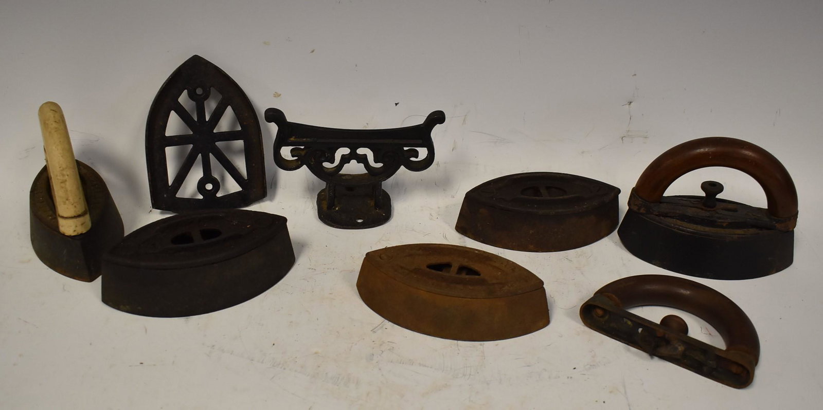 Collectors Cast Iron Lot (7): Lot Includes 5 Irons 2 without handles. 1 Trivet (5"x6") and 1 Boot hook (4"X6")