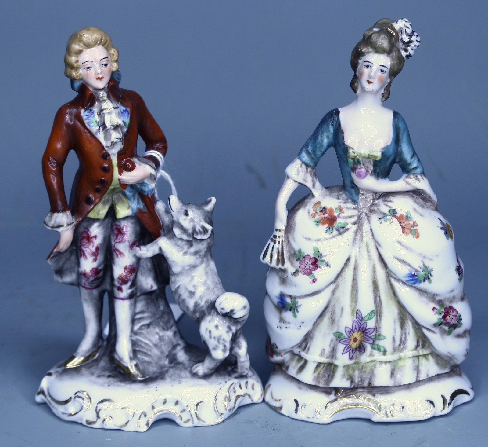 Antique Baroque Porcelain Figures: Man with a dog and a figure of a woman. Both with differing crown marks and numbered 3902 and 3903. 5 1/2"H.