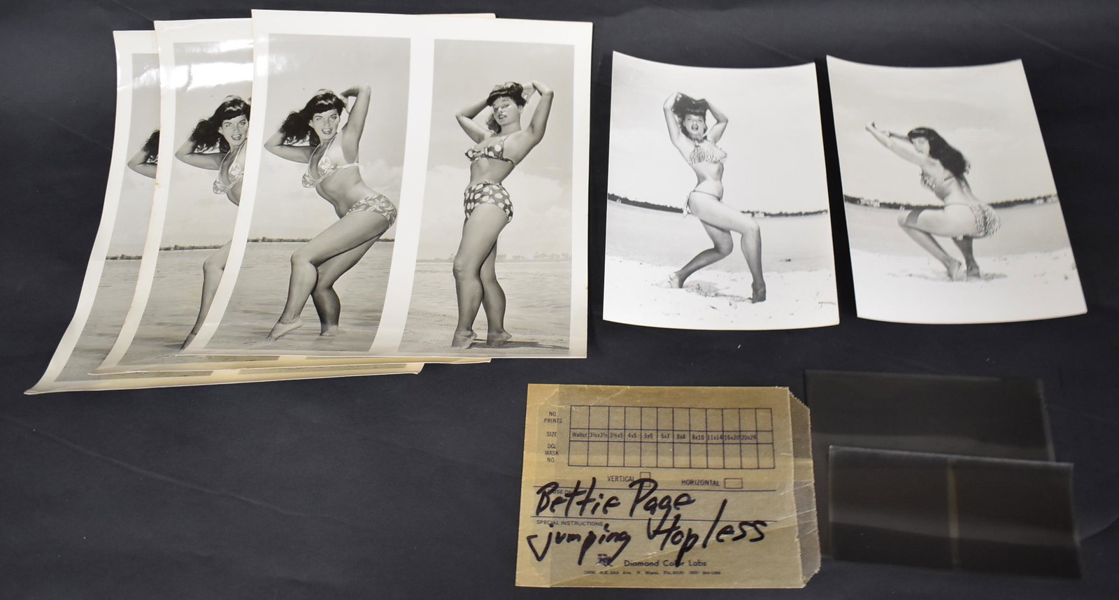 Bettie Page Lot of Photos & Negatives (8): Double swimsuit photos (3). Beach photos (2). Negative jumping topless. 2 contact negatives, one of Bunny Yeager shooting the Bettie Page negative attached to it. 8 in the lot. 8 x 10 inches 5 x 7 inc