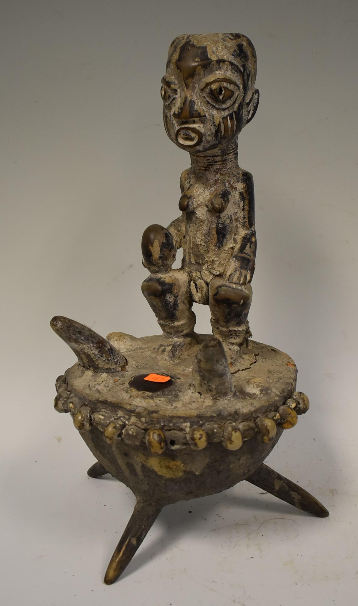 Unusual Yoruba Ceramic Figure: Seated on a kettle drum. With sea "shell" border. 11"H (figure) 17"H Overall