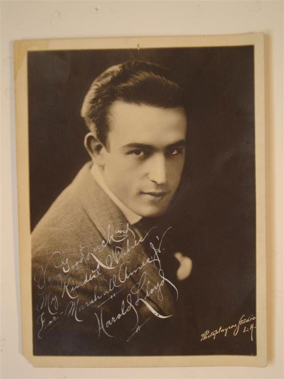 HAROLD LLOYD INSCRIBED PHOTOGRAPH: "Good Luck and My Kindest Wishes for Marshall Ames, Jr. Harold Lloyd" in white pen. Marked lower right Photoplayers Studio L.A. 6" x 8" (VF-F) (Small pin hole top middle and left corner. Lower left of