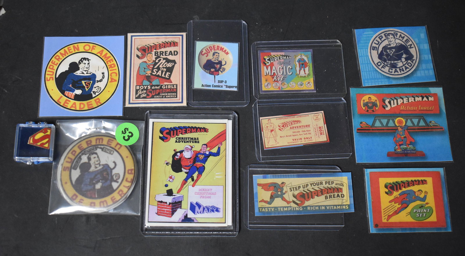 Lot of Superman Collectibles (12): Included is pin of the Superman logo; a print of an ad for a Superman pin button; an print of an ad for Superman Bread; a print of an ad for Superman Adventure at Macy's Herald Square in New York City