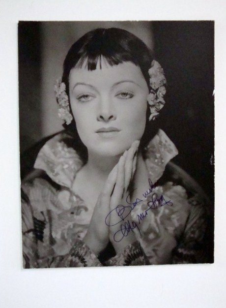 SIGNED MYRNA LOY PHOTOGRAPH: Inscribed best wishes Myrna Loy in purple ink on eavy cardboard stock 11x14 VF-F