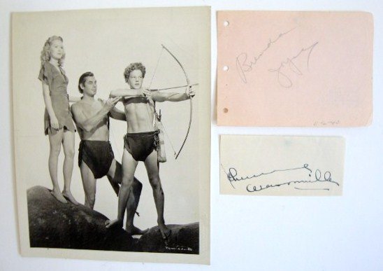 JOHNNY WEISSMULLER PHOTO AND AUTOGRAPH: Photographed with Brenda Joyce and John Sheffield in a publicity photo for Tarzan and the Leopard Woman. Blind stamps (2) for National Screen Service. Signed on 4-3/4 x 2-1/4 slip of paper, Johnny Wei