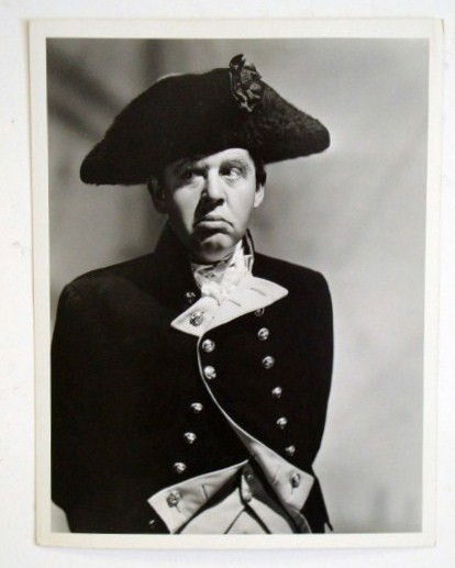 CHARLES LAUGHTON BY CLARENCE SINCLAIR BULL: With a backstamp for Clarence Sinclair Bull and Dell Publishing. Publicity snipe for Laughton's role as Captain Bligh in Mutany on the Bounty. 10 x 13. VF