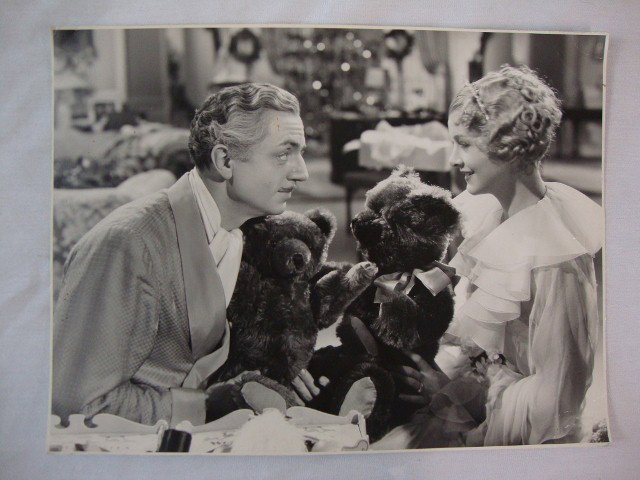 WM. POWELL MYRNA LOY PHOTOGRAPH BY CRONEnWETH: Double weight deluxe photo of the two stars in The Great Ziegfield with their teddy bears. Back stamp for MGM & Ed Cronenweth. 9 1/2 x 12 1/2