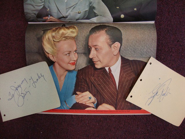 1943 PHOTOPLAY MAGAZINE & AUTOGRAPHS: 1943 Photoplay Magazine together with autographs for Betty Grable, "To Jimmy, Betty Grable" in blue ink on a blue album page and for George Raft in blue ink on a yellow album page. Both stars are feat