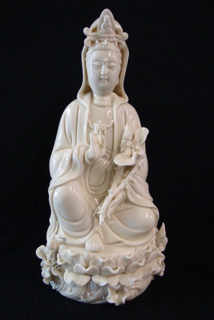 CHINESE PORCELAIN FIGURE OF QUAN YIN: blanc de chine porcelain figure of a Quan Yin seated upon lotus laden base; 10-1/2in. H. (2 fingers - as is)