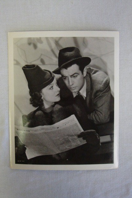 MYRNA LOY & ROBERT TAYLOR BY WILLINGER: Deluxe cardboard stock photograph with a backstamp for MGM & Willinger and a publicity snipe for their roles as bride and groom in Lucky Night - 1939. Douglas Whitney Collection stamp. 8 x 10. VF-Exc.