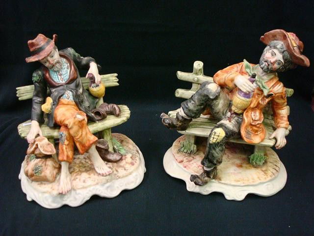 PAIR CAPODIMONTE FIGURES ON BENCHES: Each is a figure of a man drinking wine on a bench. One in bare feet, the other in tattered boots. Marked Capodimonte on the bases with the letter "N" beneath a crown. Made in Italy. 11" high.