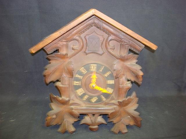 BLACK FOREST CUCKOO CLOCK: carved walnut cuckoo clock (with weights); 15in. H. , 22in. With pendulum, 9in. W.