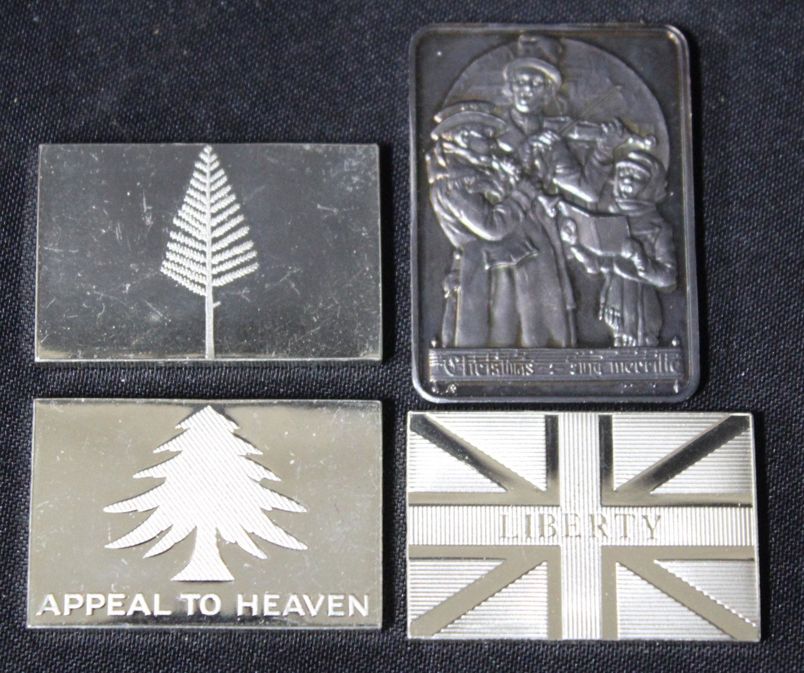 Sterling Silver Flag & Rockwell Ingots (4): 3 flag ingots , Pine Tree , Fort Johnson, Mass. Navy Flag. Marked "415 Grains of Sterling". Also in lot 1974 Annual Christmas Ingot. Norman Rockwell's "Christmas Trio". 1 troy oz. 999 fine silver Four